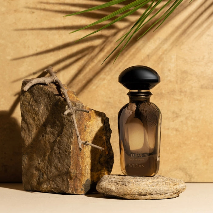 Widian - Limited Collection - Luban Parfumflakon in dunklem Glas neben Natursteinen und getrocknetem Ast