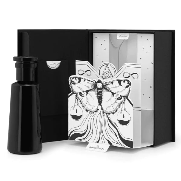 Argentum - Magician - Fire schwarzer Flakon neben geöffneter Box mit kunstvoller Schmetterlingsillustration in Schwarz-Weiß