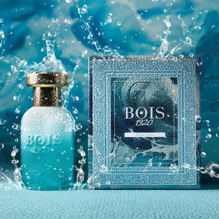 Bois 1920 - Trasparenti - Marasma Parfumflakon und Verpackung mit lebendigem Wasser-Spritzer vor blauem Hintergrund