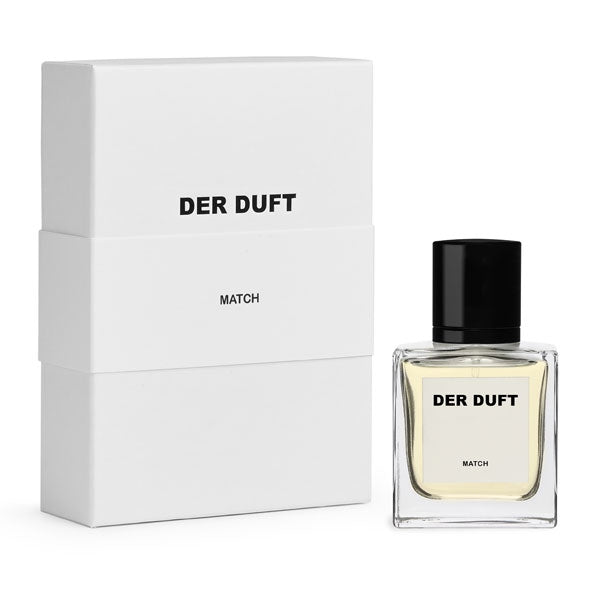 DER DUFT - Match Parfum mit klarem Glas, hellgelbem Inhalt und schwarzem Verschluss neben eleganter weißer Verpackung