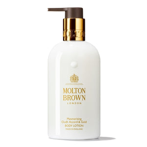 Molton Brown - Mesmerising Oudh Accord & Gold Body Lotion in elegantem weißem Spender mit goldfarbenem Pumpspender