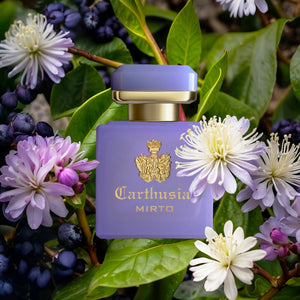 Carthusia - Intenso Collection - Mirto zeigt violetten Flakon mit goldenem Wappen umgeben von weißen und lila Blüten