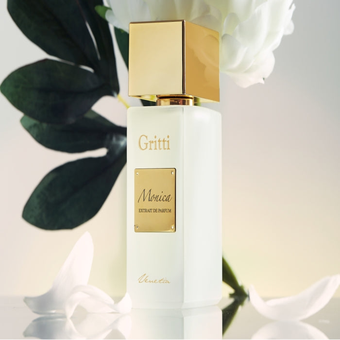 Gritti - White Collection - Monica - Limited Edition edler weißer Flakon mit goldfarbenem Verschluss und Schriftzug vor zartem Blumenhintergrund