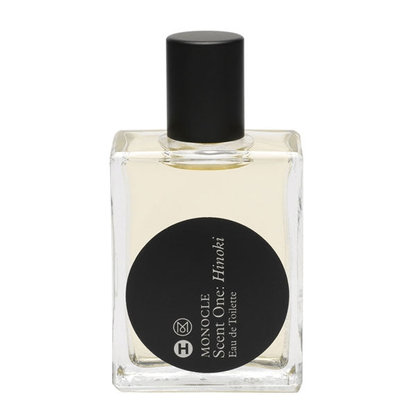 Comme des Garçons - Monocle - Scent One: Hinoki Flakon mit schwarzem Etikett und klarer Form vor weißem Hintergrund