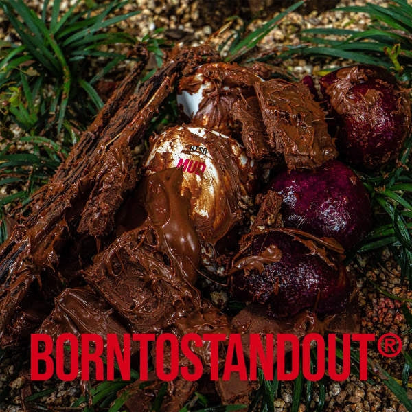 BORNTOSTANDOUT - Mud Parfumflakon umgeben von feuchtem Schlamm und Naturmaterialien in erdigen Tönen