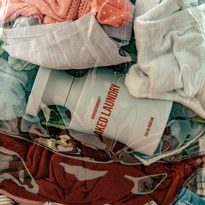 BORNTOSTANDOUT - Naked Laundry Flakon zwischen gewaschener Wäsche in natürlicher, frischer Atmosphäre aufbewahrt