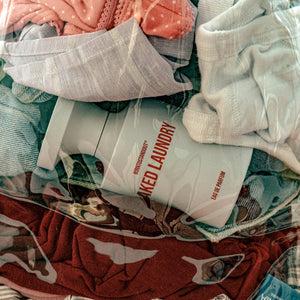 BORNTOSTANDOUT - Naked Laundry Flakon zwischen gewaschener Wäsche in natürlicher, frischer Atmosphäre aufbewahrt