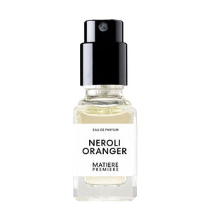 Matière Première - Neroli Oranger zeigt kleinen Parfumflakon mit hellem Duft und schwarzem Sprühkopf vor weißem Hintergrund