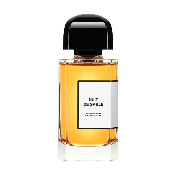 bdk Parfums - Collection Parisienne - Nuit de Sable klarer Flakon mit bernsteinfarbener Flüssigkeit und schwarzem Deckel vor weißem Hintergrund
