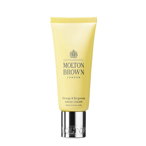 Molton Brown - Orange & Bergamot Hand Cream in gelber Tube mit silbernem Verschluss auf weißem Hintergrund