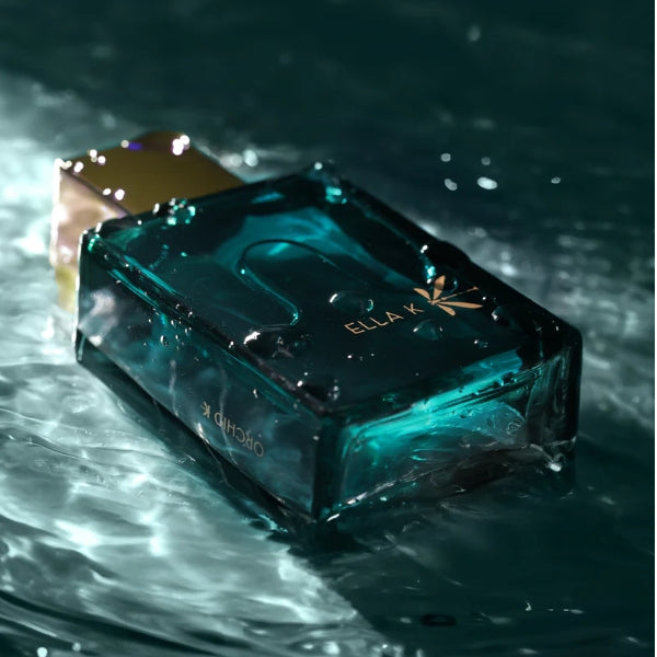 Ella K - Orchid K Parfümflakon in tiefgründigem Türkis mit goldenem Verschluss und elegantem Schriftzug im Wasserlichtspiel