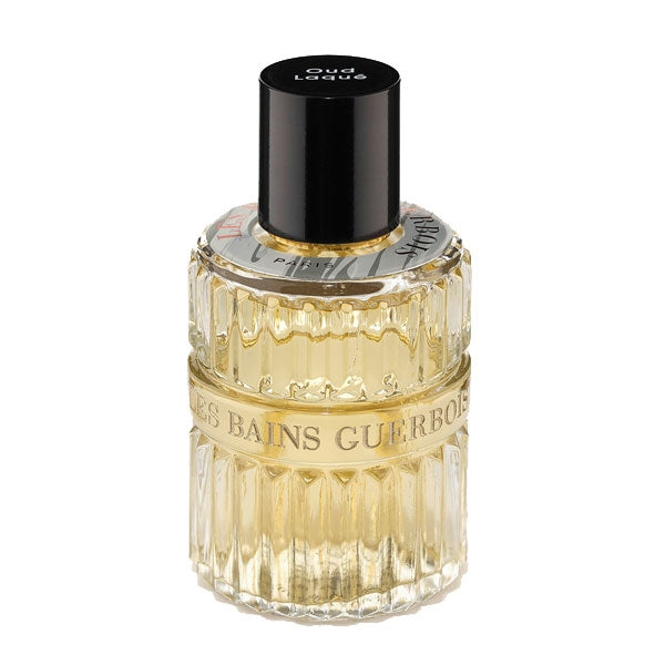 Les Bains Guerbois 1885 - Oud Laqué Parfumflakon mit goldgelbem Duft und geriffeltem Glas vor weißem Hintergrund