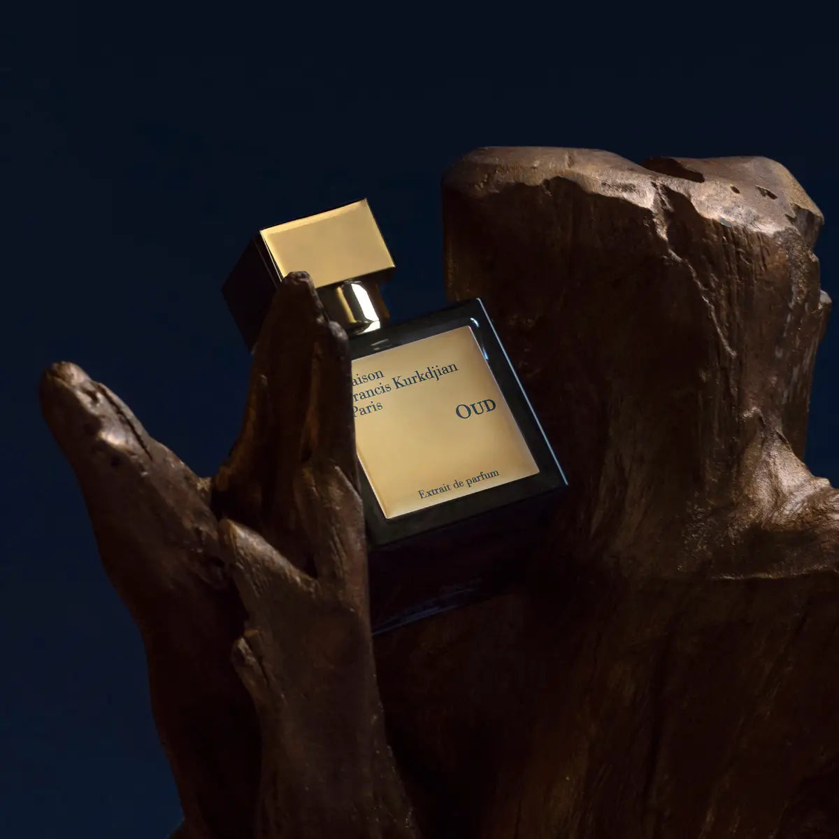 Maison Francis Kurkdjian Paris - Oud - Extrait de Parfum Flakon mit goldfarbenem Verschluss vor dunklem Holzdetail