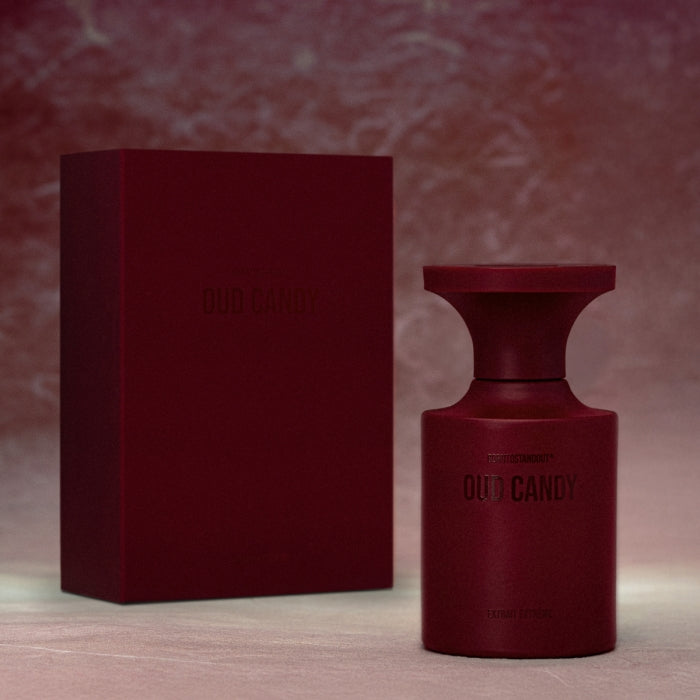 BORNTOSTANDOUT - Oud Candy Flakon und Verpackung in sattem Dunkelrot mit mattem Finish vor stimmungsvollem Hintergrund