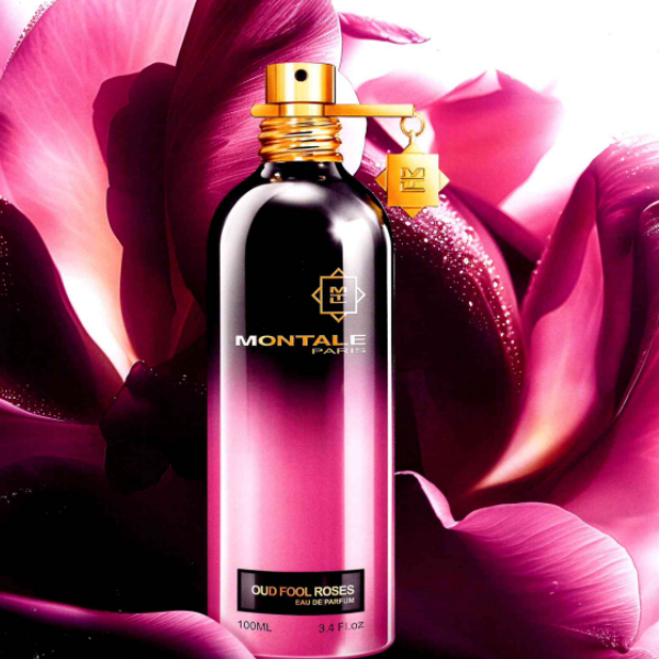 Montale - Oud Fool Roses Parfumflakon mit pink-schwarzem Farbverlauf und goldenem Sprühkopf vor Rosenblüten Hintergrund
