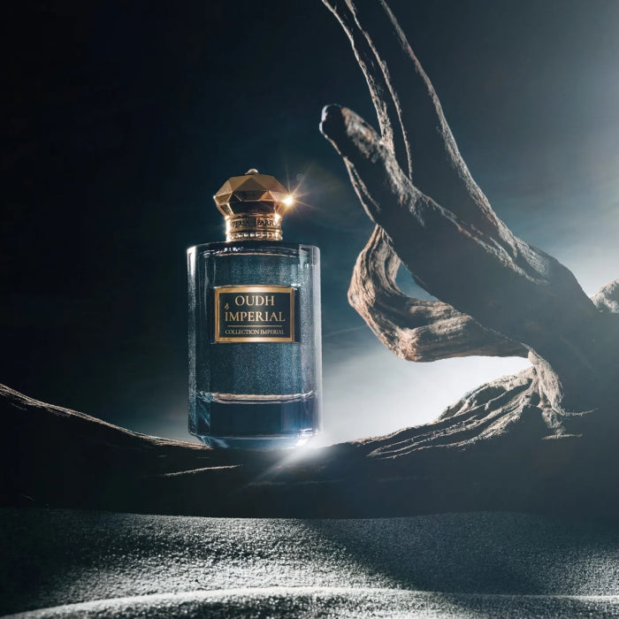 Imperial Parfums - Oudh Imperial Flakon mit facettiertem goldfarbenem Verschluss vor dramatischem Holzarrangement