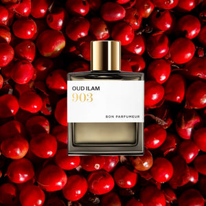 Bon Parfumeur - Les Extraits - 903 Oud Ilam Parfumflakon mit goldenem Verschluss vor roten Pfefferfrüchten