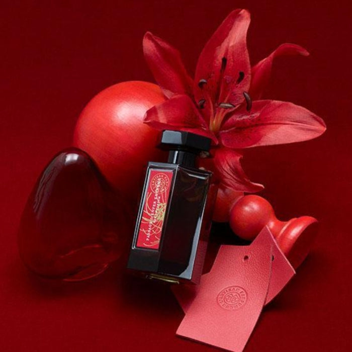 L'Artisan Parfumeur - La Collection - Passage d'Enfer Extrême Flakon mit roter Lilie und dekorativen roten Objekten auf rotem Hintergrund