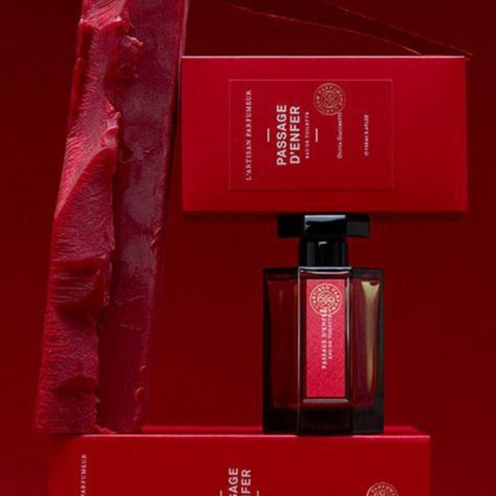 L'Artisan Parfumeur Passage d'Enfer perfume in dark red rectangular bottle with black cap and matching red packaging on red background