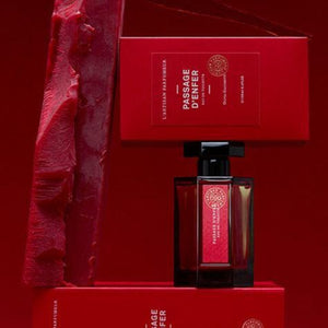 L'Artisan Parfumeur Passage d'Enfer perfume in dark red rectangular bottle with black cap and matching red packaging on red background