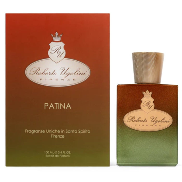 Roberto Ugolini - Patina Parfumflakon mit grün-braunem Farbverlauf und cremefarbenem Verschluss vor farblich abgestimmter Verpackung
