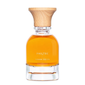 Hiram Green - Philtre Parfumflakon mit bernsteinfarbener Flüssigkeit und natürlichem Holzverschluss vor weißem Hintergrund