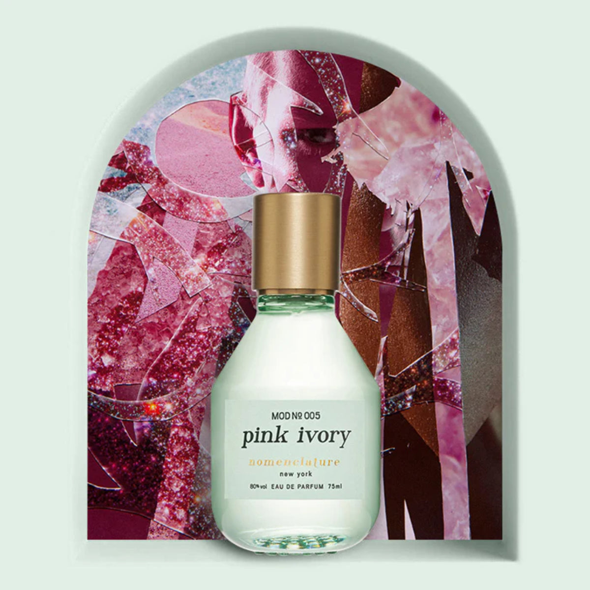 Nomenclature - pink ivory Parfumflakon mit mattiertem Glas und goldenem Verschluss vor abstraktem rosafarbenem Hintergrund