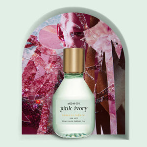 Nomenclature - pink ivory Parfumflakon mit mattiertem Glas und goldenem Verschluss vor abstraktem rosafarbenem Hintergrund