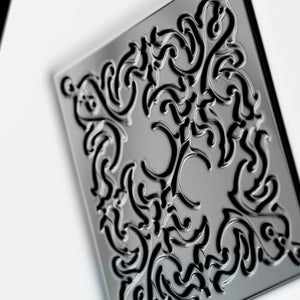 Initio - Hedonist Collection - Power Self mit filigranem schwarzem Ornament auf glänzender Oberfläche vor hellem Hintergrund