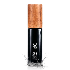 EBENHOLZ - Protect Balm Anti Stress Flakon mit mattschwarzem Körper und Holzdeckel, umgeben von Wasserspritzern vor weißem Hintergrund