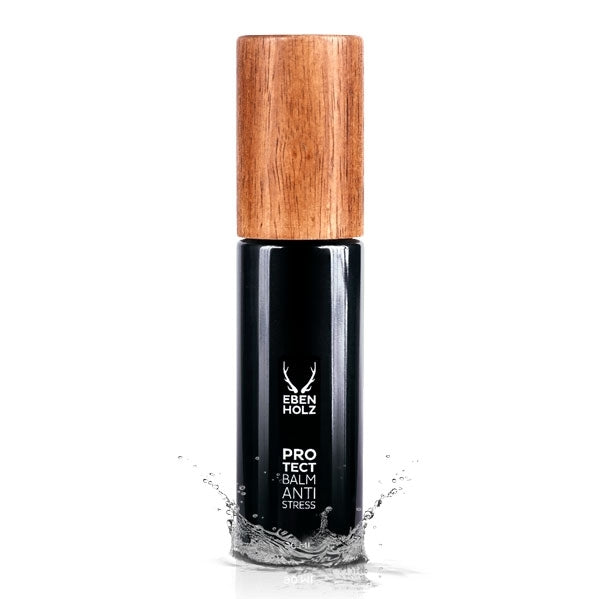 EBENHOLZ - Protect Balm Anti Stress Flakon mit mattschwarzem Körper und Holzdeckel, umgeben von Wasserspritzern vor weißem Hintergrund