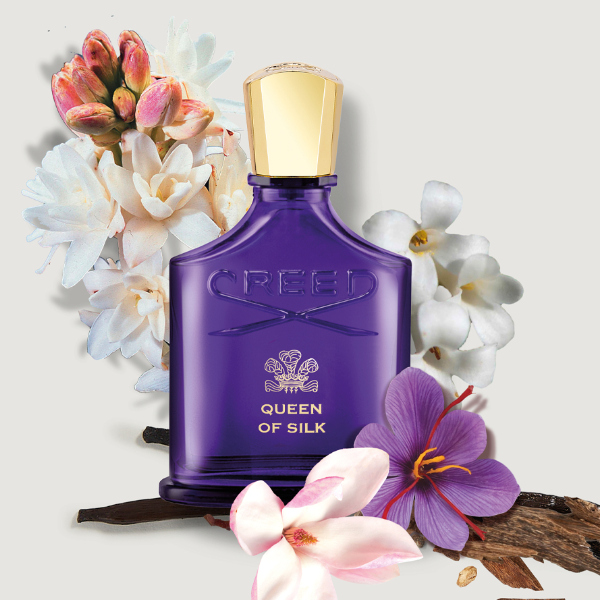 Creed - Queen of Silk Flakon in tiefem Violett mit goldfarbenem Verschluss und floralen Akzenten auf hellem Hintergrund