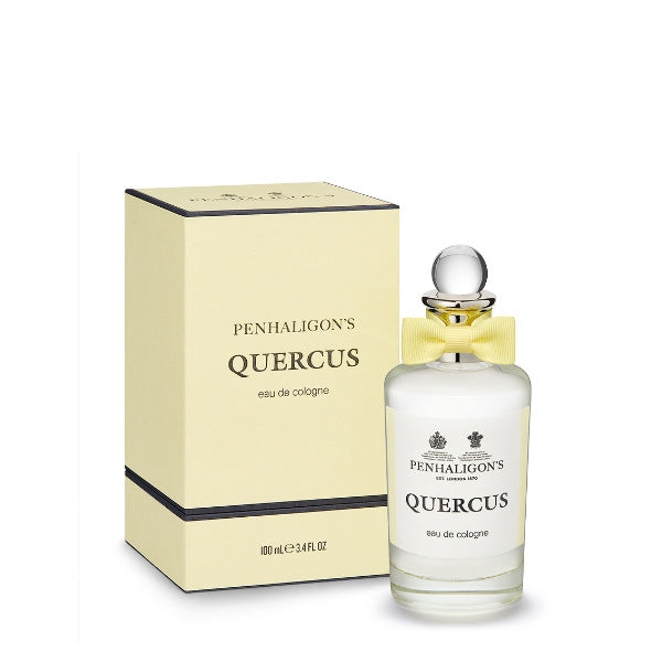 Penhaligon's Quercus cologne in clear bottle with yellow bow beside pale yellow box with black trim on white background