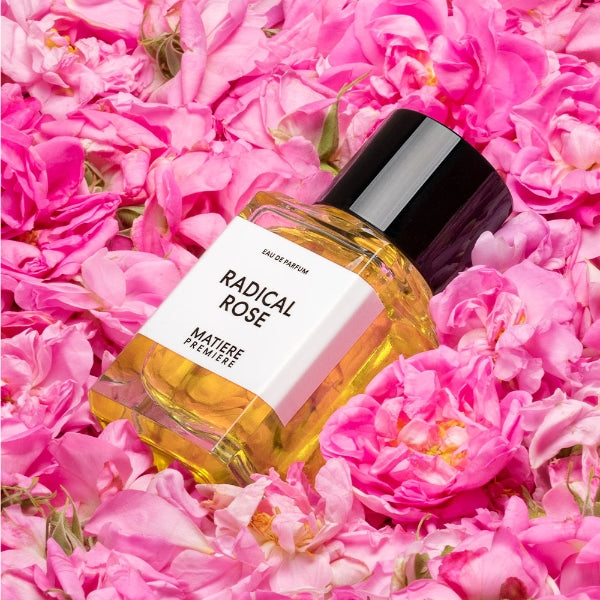 Matière Première - Radical Rose zeigt Flakon mit schwarzem Verschluss auf Betten aus rosa Rosenblüten