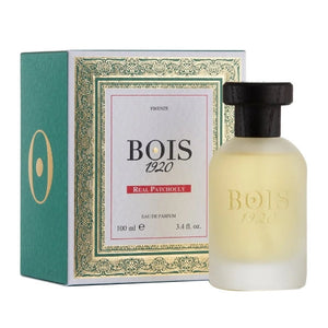 Bois 1920 - Real Patchouly Parfum mit matter Flasche und schwarzem Holzverschluss vor grün-goldener Verpackung