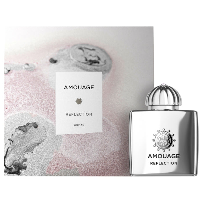 Amouage - Reflection Woman Parfum mit silbernem Flakon vor schimmerndem pastellfarbenem Hintergrund