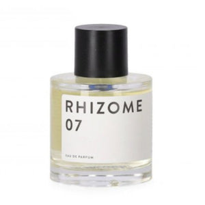 Rhizome - 07 klarer runder Flakon mit schlichtem weißen Etikett und schwarzem Verschluss vor hellem Hintergrund