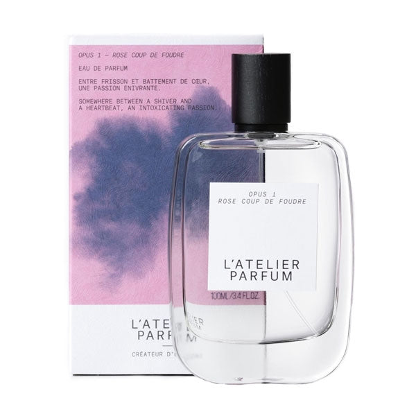 L'Atelier Parfum - Opus 1 - Rose Coup de Foudre Flakon vor zartem rosa und blauem Hintergrund mit elegantem Design