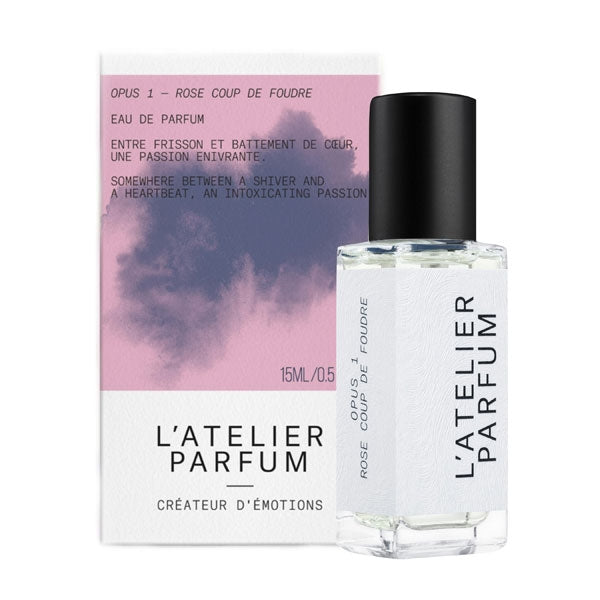 L'Atelier Parfum - Opus 1 - Rose Coup de Foudre klarer Flakon mit schwarzem Verschluss vor rosa-blauem Hintergrund