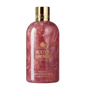 Molton Brown - Rose Dunes - Bath & Shower Gel Flasche mit schimmerndem rosa Duschgel und goldfarbenem Verschluss vor weißem Hintergrund