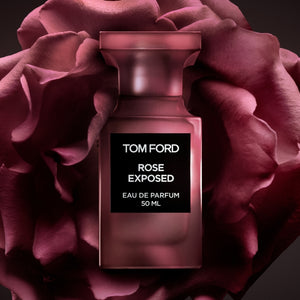 Tom Ford - Private Blend - Rose Exposed Parfumflakon in dunklem Rosa vor großer Rosenblüte inszeniert