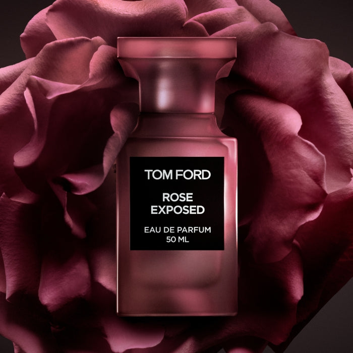 Tom Ford - Private Blend - Rose Exposed Parfumflakon in dunklem Rosa vor großer Rosenblüte inszeniert