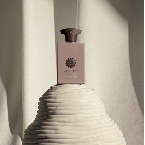 Amouage - Library Collection - Opus XII - Rose Incense Flakon in sanftem Rosa mit edlem Siegel vor hellen Stofffalten