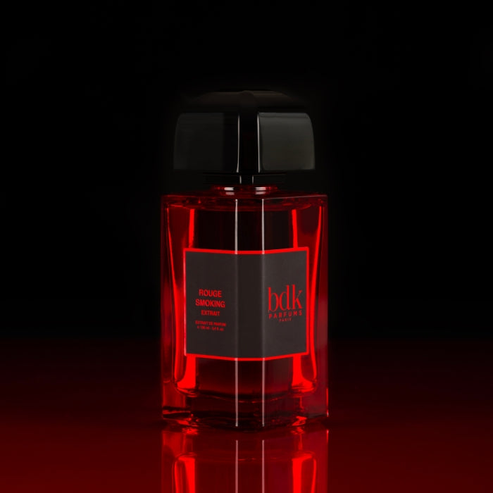 bdk Parfums - Rouge Smoking - Extrait de Parfum roter Flakon mit schwarzem Verschluss vor dunklem Hintergrund