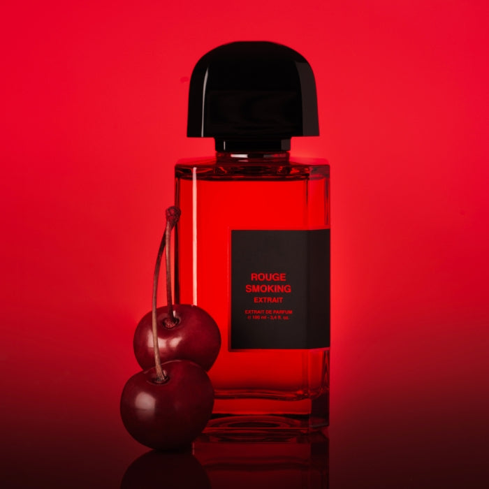 bdk Parfums - Rouge Smoking - Extrait de Parfum roter Flakon mit schwarzem Verschluss vor rotem Hintergrund