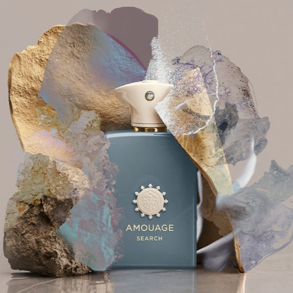 Amouage - Odyssey Collection - Search Flakon in elegantem Blauton mit auffälligem Emblem vor künstlerischem Hintergrund