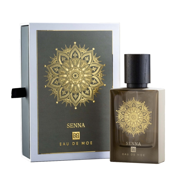 Eau De Moe - Senna Parfumflakon in braunem Glas mit schwarzem Holzdeckel und goldfarbenem Mandalamotiv neben passender Verpackung