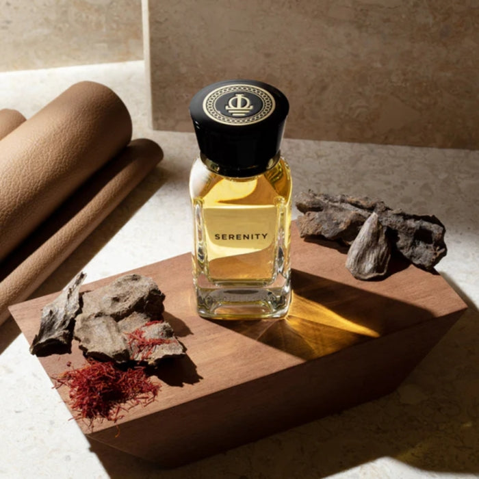 Omanluxury - Serenity Parfümflakon mit goldfarbenem Duft auf Holzblock umgeben von aromatischen Harzen und Gewürzen