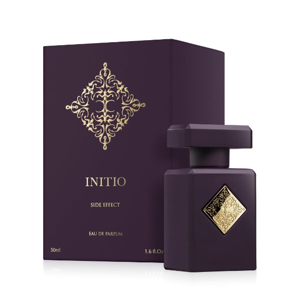 Initio - Carnal Blend - Side Effect Parfumflakon in tiefviolett mit goldverzierter Plakette und passender Box vor weißem Hintergrund