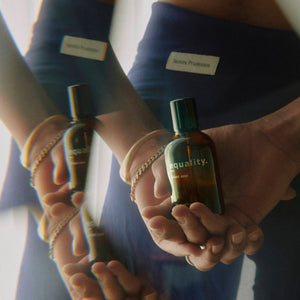equality. fragrances - silent vow braune Glasflasche in Hand, reflektiert mit weichem Licht und dezentem Hintergrund